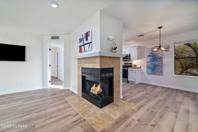 living room featuring a fireplace and light wood-type flooring