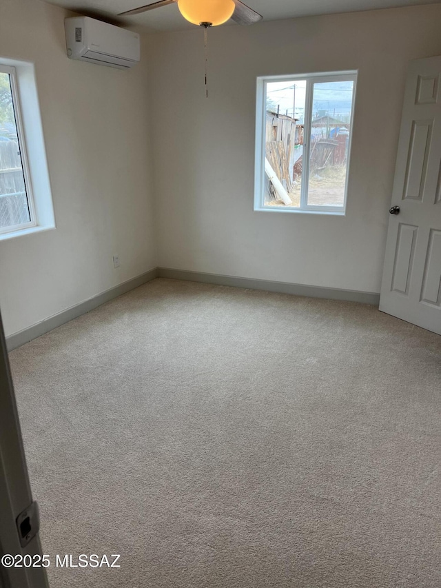 spare room with carpet flooring, a wall mounted air conditioner, and ceiling fan