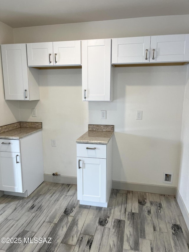 kitchen with light hardwood / wood-style flooring and white cabinets