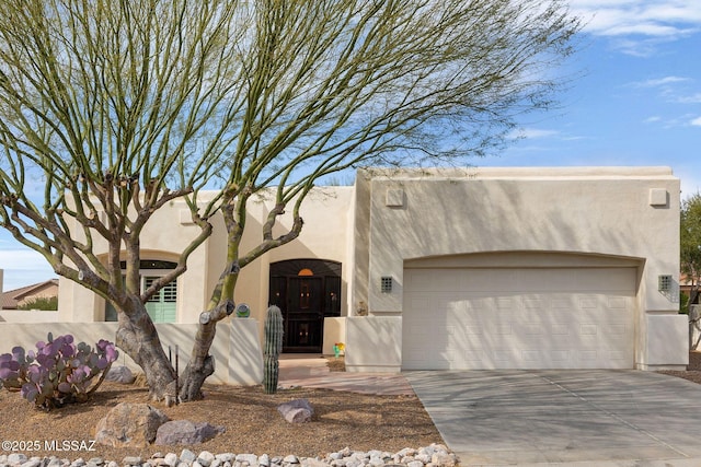 pueblo revival-style home featuring a garage