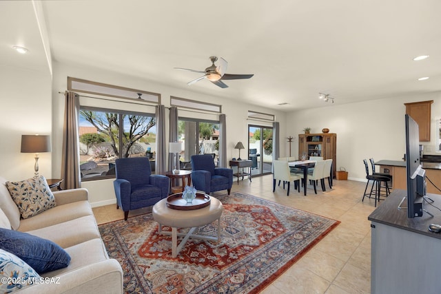 living room featuring light tile patterned flooring, track lighting, and ceiling fan