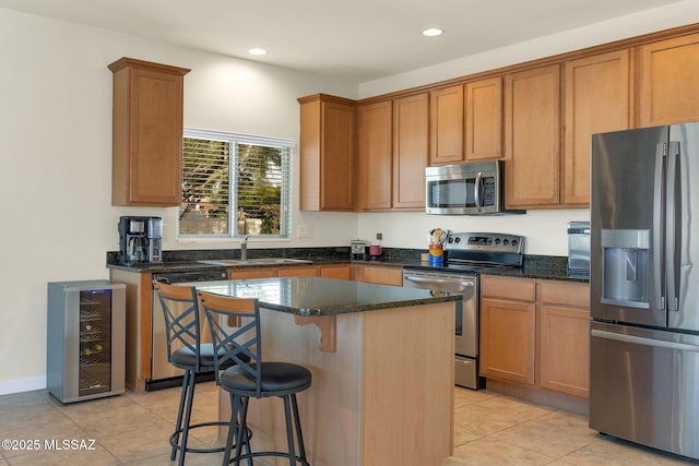 kitchen featuring a kitchen island, appliances with stainless steel finishes, sink, beverage cooler, and dark stone counters