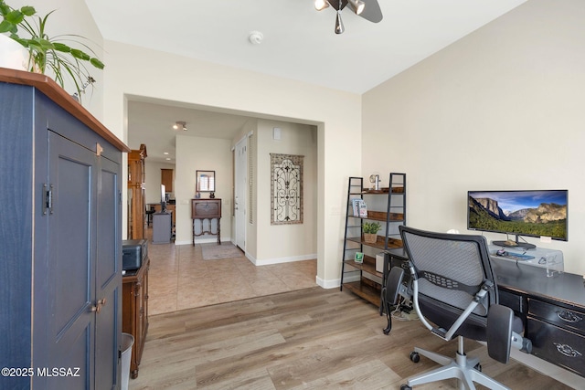 home office with light hardwood / wood-style flooring and ceiling fan