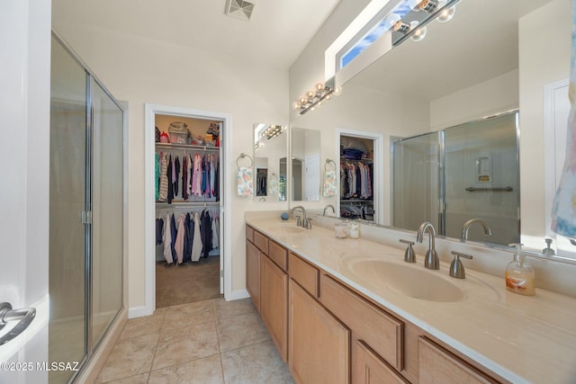 bathroom featuring vanity, tile patterned floors, and walk in shower