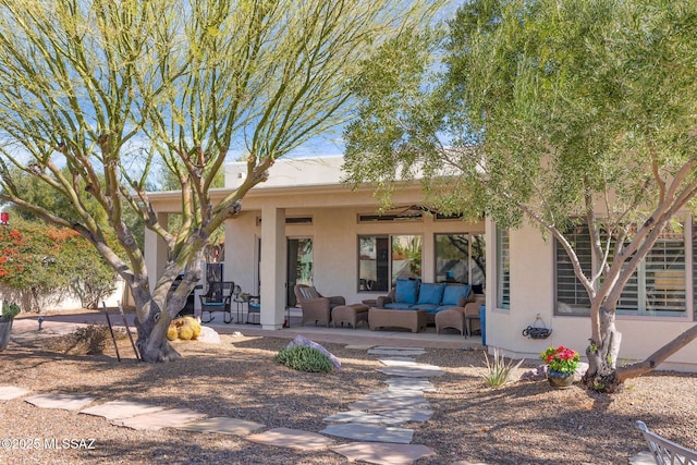 pueblo revival-style home with outdoor lounge area and a patio