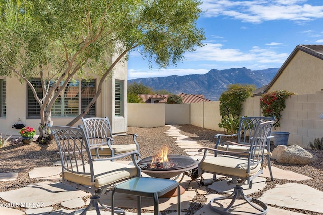 view of patio / terrace with a mountain view and an outdoor fire pit