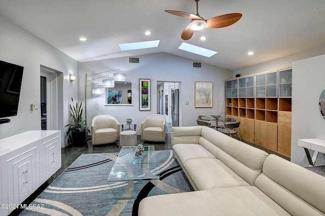 living room with ceiling fan and vaulted ceiling with skylight