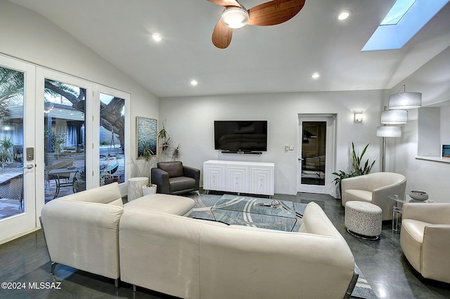 living room with vaulted ceiling with skylight and ceiling fan