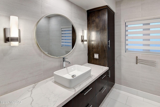 bathroom featuring tile patterned flooring, vanity, and tile walls