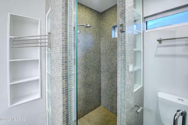 bathroom featuring toilet and tiled shower