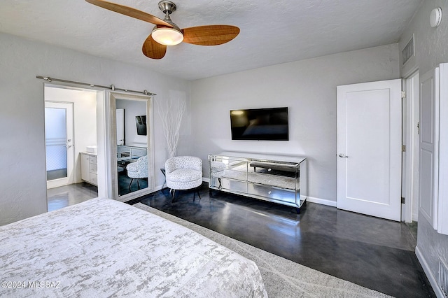 bedroom featuring ensuite bath, a textured ceiling, a barn door, and ceiling fan