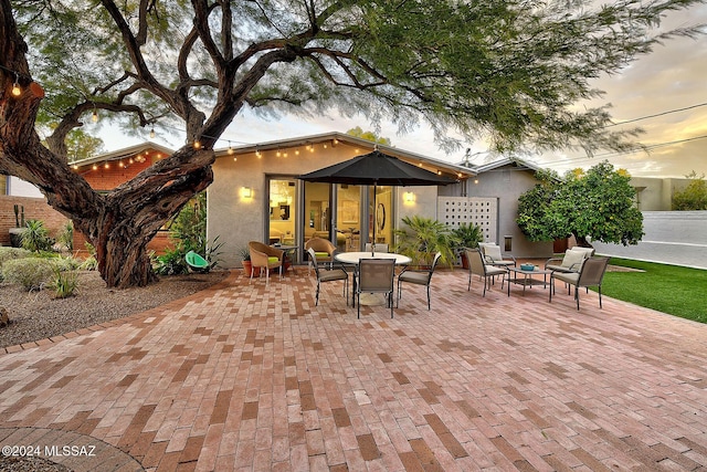 patio terrace at dusk featuring an outdoor living space