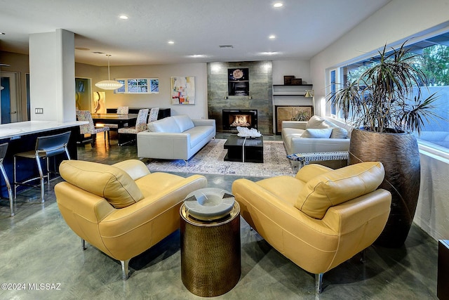 living room with a large fireplace and concrete floors