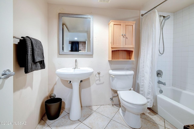 bathroom featuring shower / bath combination with curtain, tile patterned floors, and toilet