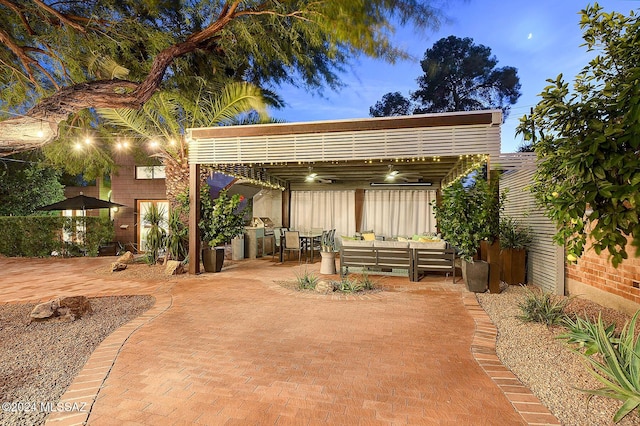 patio terrace at dusk featuring outdoor lounge area and ceiling fan