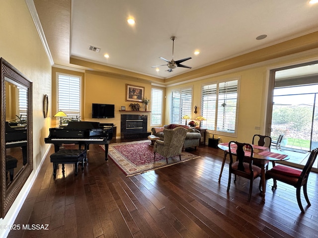 36239 S Cypress Dr, Saddlebrooke, AZ 85739 - living area featuring visible vents, dark wood finished floors, a raised ceiling, a premium fireplace, and crown molding