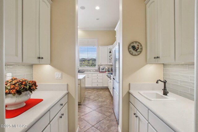 36239 S Cypress Dr, Saddlebrooke, AZ 85739 - kitchen featuring light tile patterned flooring, a sink, light countertops, decorative backsplash, and crown molding
