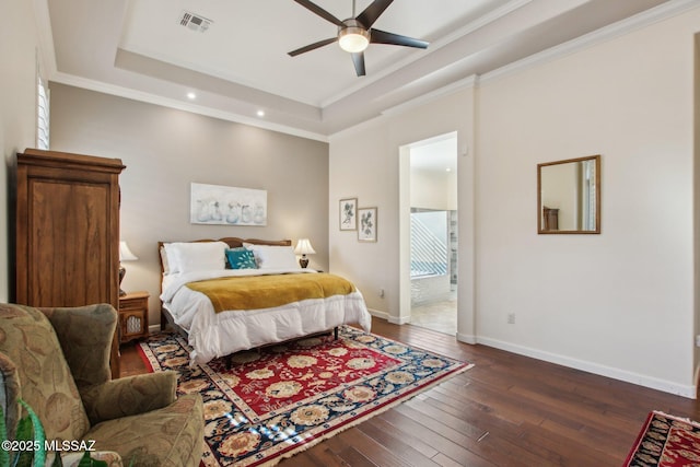 36239 S Cypress Dr, Saddlebrooke, AZ 85739 - bedroom with visible vents, baseboards, ornamental molding, dark wood-style floors, and a tray ceiling