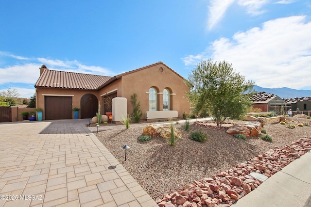 36239 S Cypress Dr, Saddlebrooke, AZ 85739 - mediterranean / spanish house with decorative driveway, stucco siding, a mountain view, a garage, and a tiled roof