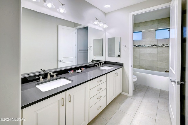 full bathroom featuring vanity, tiled shower / bath, tile patterned floors, and toilet