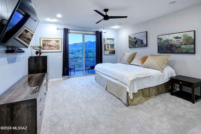 bedroom featuring a mountain view, light colored carpet, access to exterior, and ceiling fan