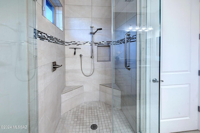 bathroom with a shower with door