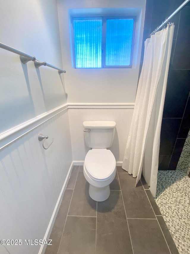 bathroom with tile patterned flooring, toilet, and walk in shower