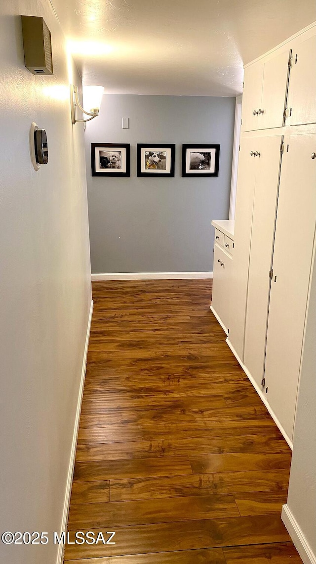 corridor with dark hardwood / wood-style flooring