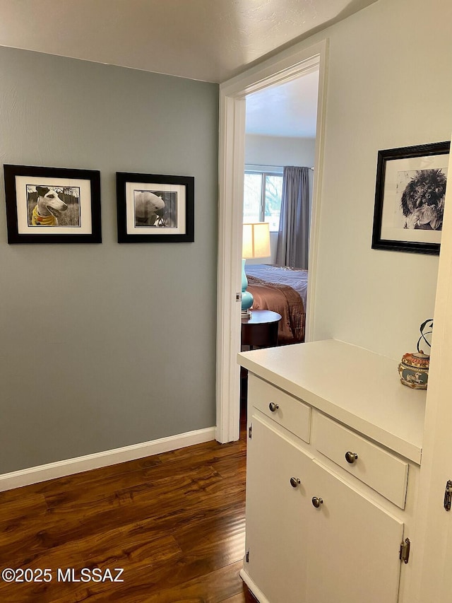 hallway with dark hardwood / wood-style flooring