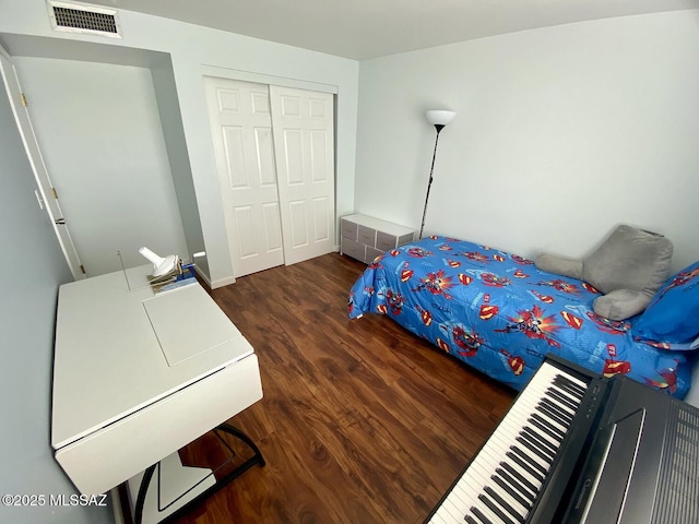 bedroom with dark hardwood / wood-style floors and a closet