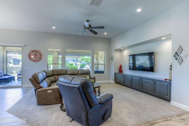 living room featuring a healthy amount of sunlight, light colored carpet, and ceiling fan