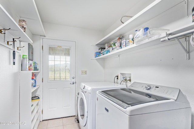 washroom featuring washer and clothes dryer and light tile patterned flooring