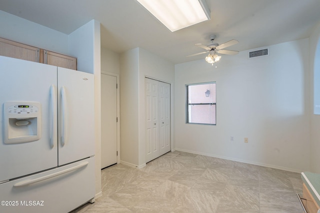 kitchen with white fridge with ice dispenser, light brown cabinets, and ceiling fan