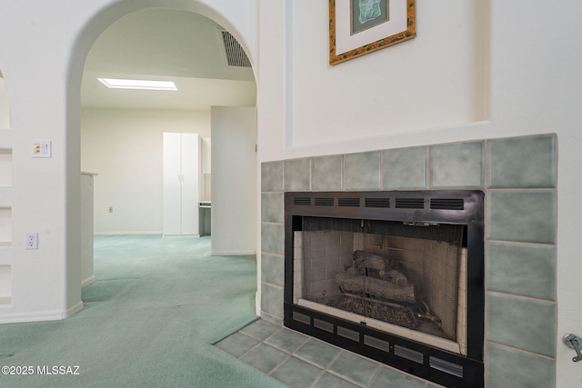 details with carpet and a tile fireplace