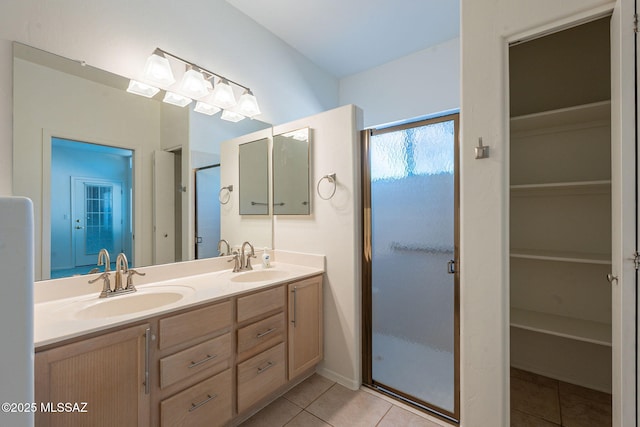 bathroom featuring a shower with door, vanity, and tile patterned floors