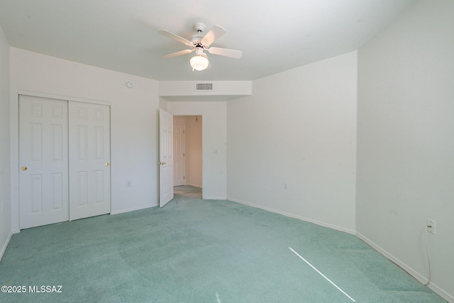 unfurnished bedroom featuring ceiling fan, light colored carpet, and a closet