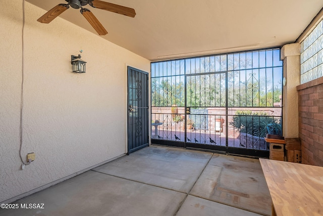 unfurnished sunroom with ceiling fan