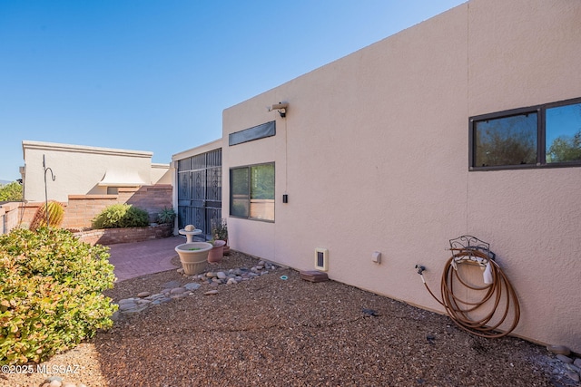 view of side of property with a patio area and a sunroom