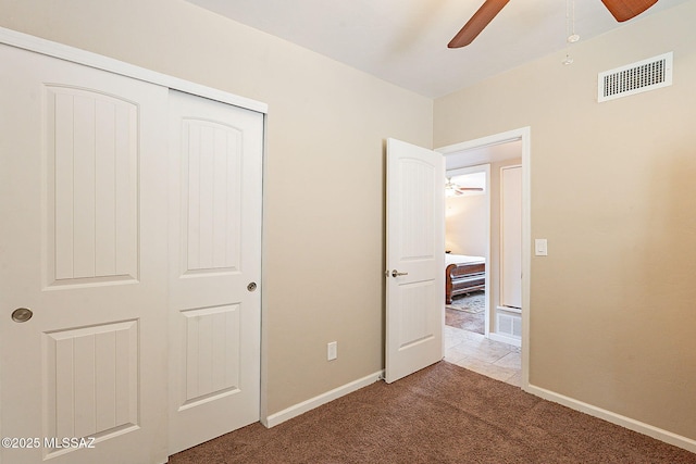 unfurnished bedroom with ceiling fan, carpet floors, and a closet