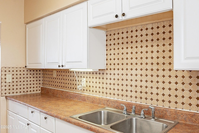 kitchen with white cabinetry, sink, and decorative backsplash