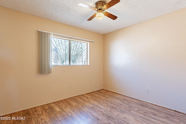 spare room featuring ceiling fan, light hardwood / wood-style floors, and a textured ceiling