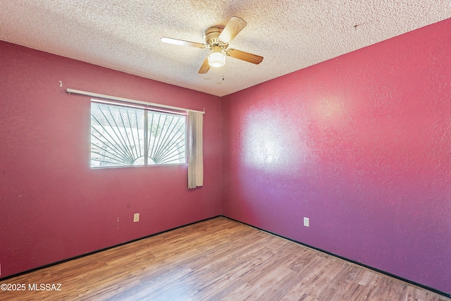 unfurnished room with ceiling fan, a textured ceiling, and light wood-type flooring