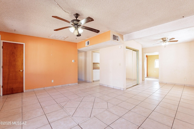 tiled empty room with a textured ceiling and ceiling fan