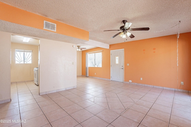 tiled spare room with ceiling fan and a textured ceiling