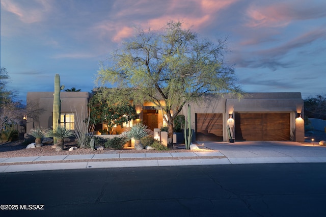 pueblo revival-style home featuring a garage