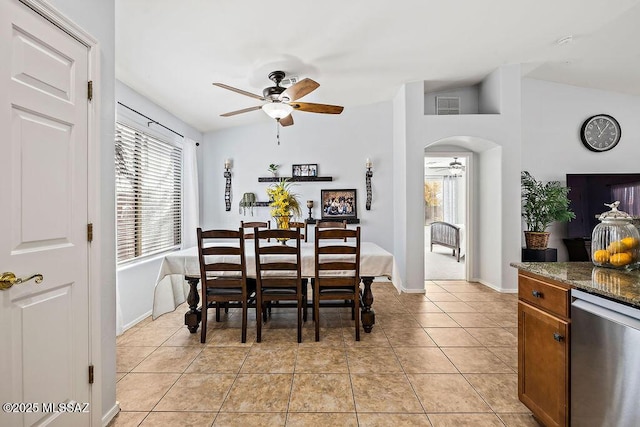 dining space featuring light tile patterned floors, ceiling fan, visible vents, baseboards, and arched walkways