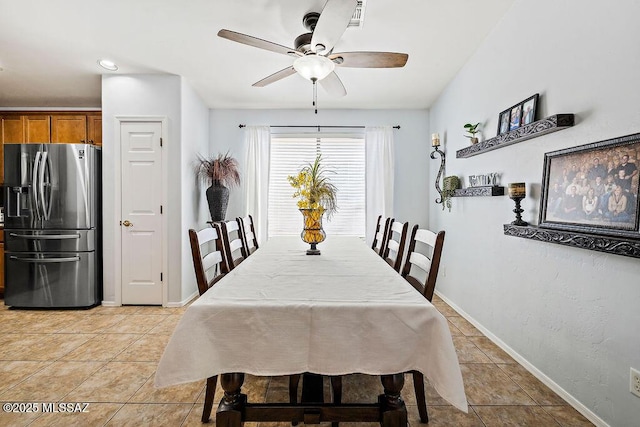 dining room with light tile patterned flooring, ceiling fan, and baseboards