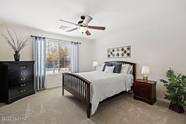bedroom with crown molding, visible vents, light colored carpet, and baseboards