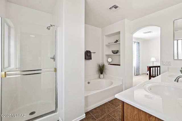 bathroom featuring a bath, double vanity, visible vents, and a shower stall