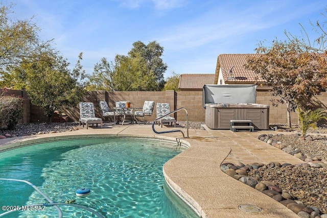 view of pool featuring a fenced backyard, a hot tub, a fenced in pool, and a patio area